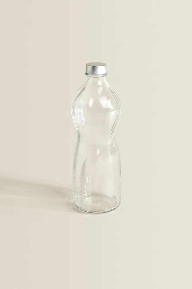 GLASS BOTTLE WITH RAISED DESIGN AND SILVER LID