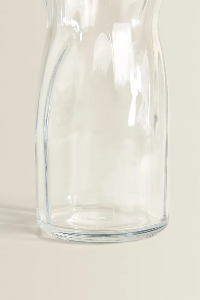 GLASS BOTTLE WITH RAISED DESIGN AND SILVER LID
