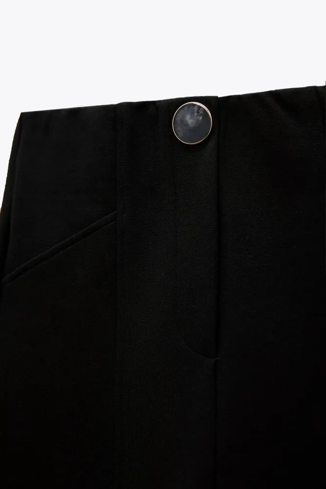 High-waisted leggings with elastic waistband and front jewel false button.