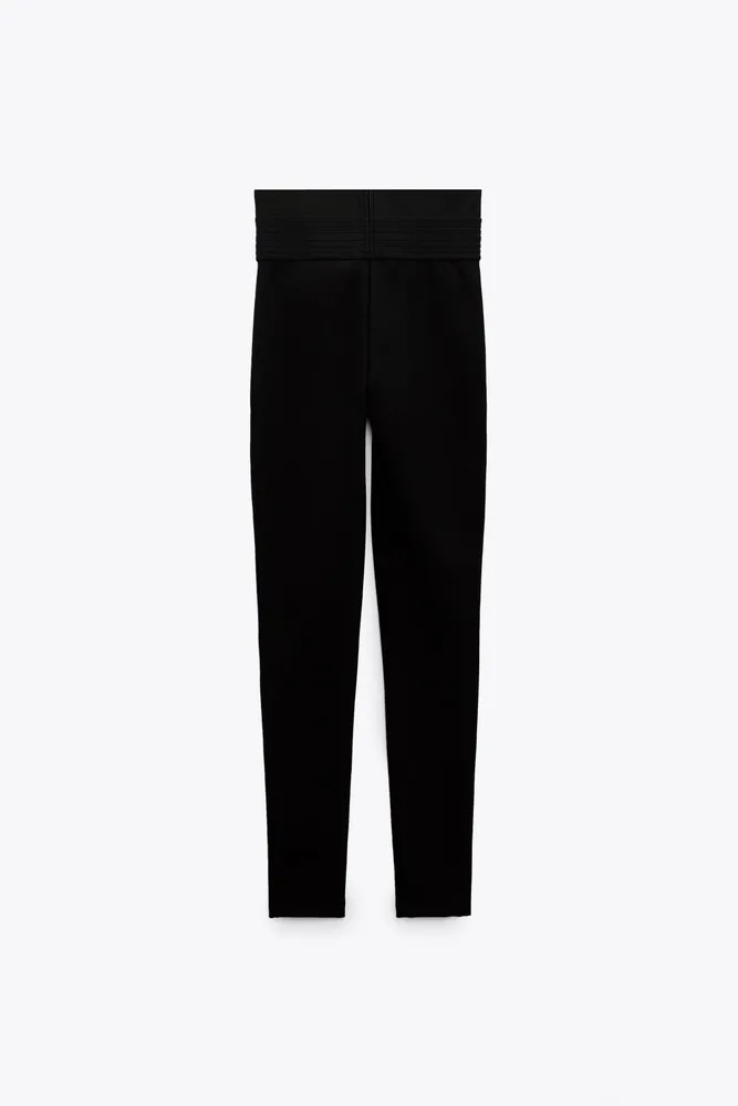High-waisted leggings with wide stretch waistband. Front pronounced seam detail.