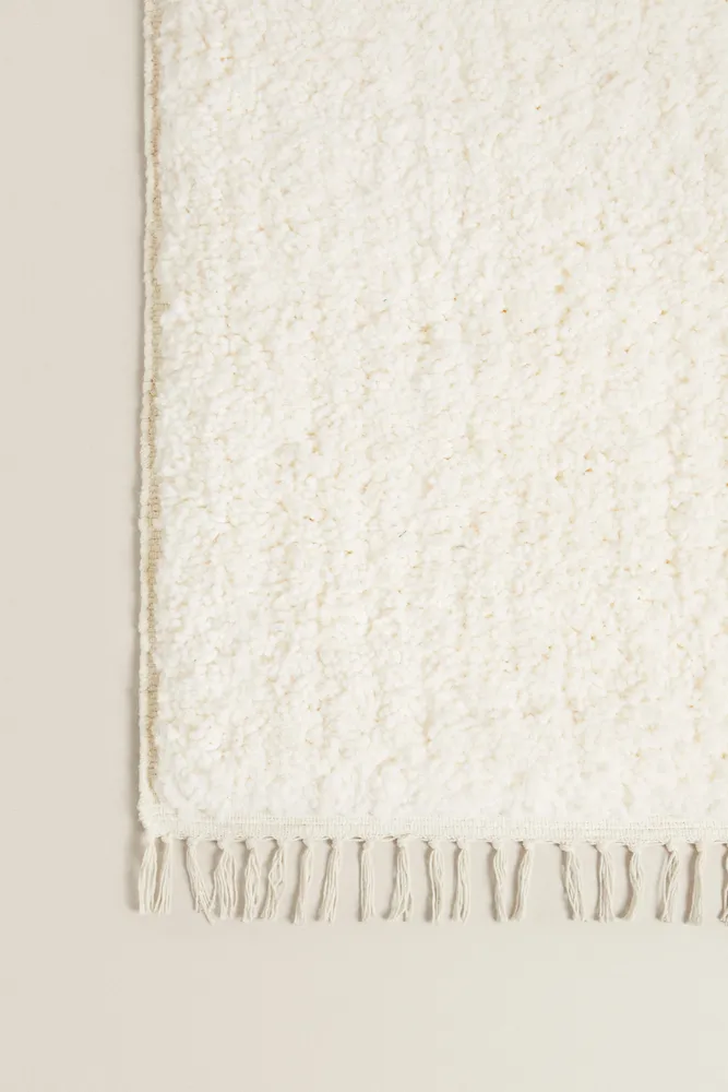 TEXTURED RUG WITH FRINGING