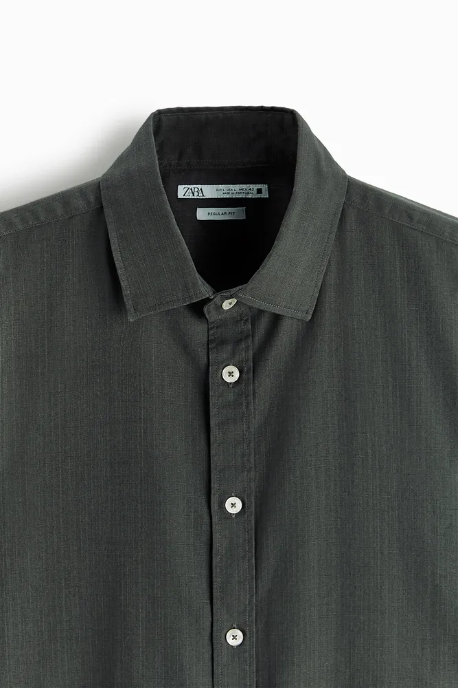Shirt made of uneven textured cotton fabric. Lapel collar and short sleeves. Front button closure.