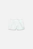 Shorts with a mid elastic waistband. Side hidden in-seam pockets. Tonal embroidery.