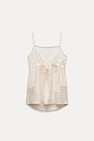 Top made of 100% viscose. Straight neckline and spaghetti straps. Matching lace appliqué adjustable drawstring at chest.