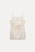 Top made of 100% viscose. Straight neckline and spaghetti straps. Matching lace appliqué adjustable drawstring at chest.