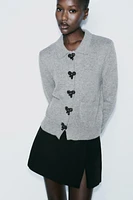 BOW-SHAPED BUTTON KNIT CARDIGAN