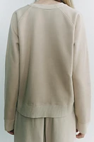 Sweatshirt made of spun cotton blend fabric. Round neck and long raglan sleeves. Tonal rib trim