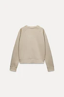 Sweatshirt made of spun cotton blend fabric. Round neck and long raglan sleeves. Tonal rib trim