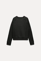 Sweatshirt made of spun cotton blend fabric. Round neck and long raglan sleeves. Tonal rib trim.