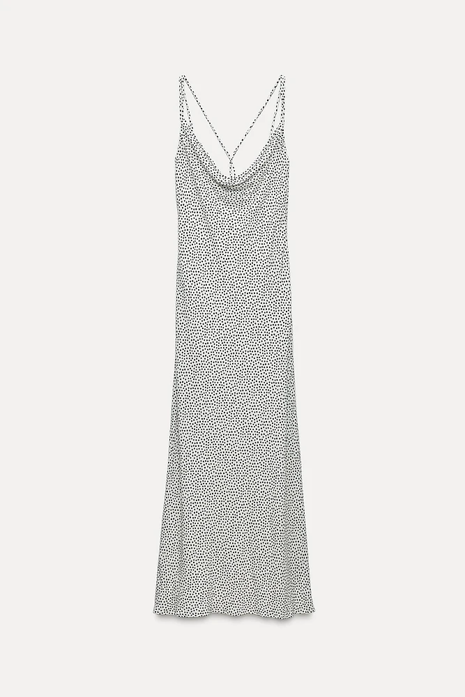 Fluid neck dress with thin straps that cross at back. Fitted waist.