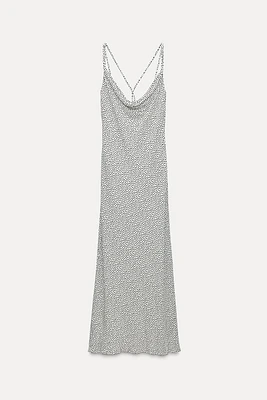 Fluid neck dress with thin straps that cross at back. Fitted waist.