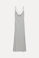 Fluid neck dress with thin straps that cross at back. Fitted waist.