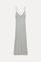 Fluid neck dress with thin straps that cross at back. Fitted waist.