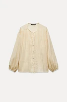 Round collar blouse with V-neck Front and long balloon sleeves. button closure.