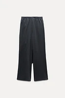 Pants made of 100% cotton. Mid-rise elastic waist. Overlapping wrap front with self-tie fastening at side.