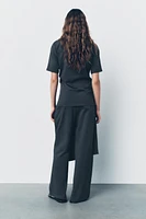 Pants made of 100% cotton. Mid-rise elastic waist. Overlapping wrap front with self-tie fastening at side.