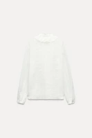 ZARA WOMAN COLLECTION<br/><br/>Blouse made with cotton. Round neck and long sleeves. Self ruffle detail. Front button closure.