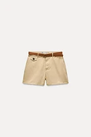 Mid-rise shorts with Front pockets and false back double welt pockets. Belt detail. zip button closure.