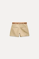 Mid-rise shorts with Front pockets and false back double welt pockets. Belt detail. zip button closure.