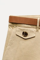 Mid-rise shorts with Front pockets and false back double welt pockets. Belt detail. zip button closure.