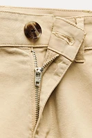 Mid-rise shorts with Front pockets and false back double welt pockets. Belt detail. zip button closure.