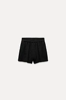 Shorts with a high elastic waistband. Front pockets. Tonal embroidered eyelet detail. Interior lining.