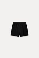 Shorts with a high elastic waistband. Front pockets. Tonal embroidered eyelet detail. Interior lining.