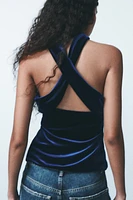 Straight neck top with straps that cross back. Interior lining. Hidden zip closure at side.