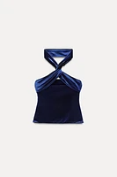 Straight neck top with straps that cross back. Interior lining. Hidden zip closure at side.