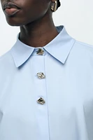 Shirt with lapel collar and long sleeves. Front closure hidden buttons embossed gold buttons.