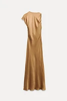 Round neck dress with asymmetric sleeves and front golden appliqué. Fitted waist.