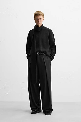 Wide fit pants. Front pleats at waist. Side pockets and back welt pockets. zip hidden metal hook closure.