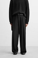 Wide fit pants. Front pleats at waist. Side pockets and back welt pockets. zip hidden metal hook closure.