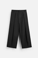 Wide fit pants. Front pleats at waist. Side pockets and back welt pockets. zip hidden metal hook closure.