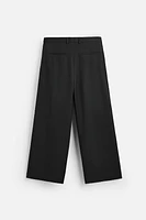 Wide fit pants. Front pleats at waist. Side pockets and back welt pockets. zip hidden metal hook closure.