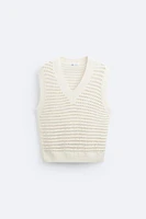 Open knit structured vest. Sleeveless with V-neckline. Rib trim.