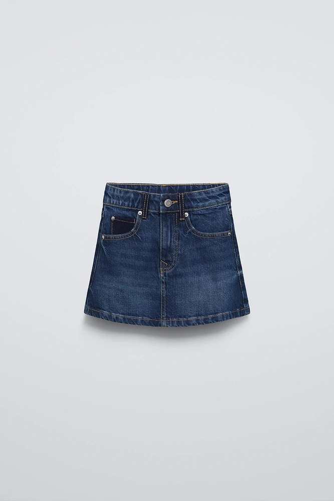 Denim skirt with adjustable interior waistband and Front button closure. pockets back patch pockets.