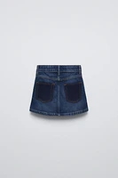 Denim skirt with adjustable interior waistband and Front button closure. pockets back patch pockets.