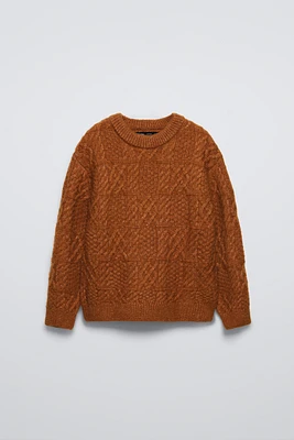 knit sweater with round neck and long sleeves. Cable details.