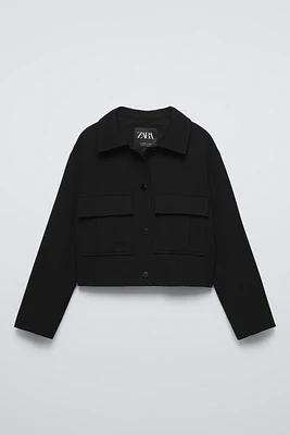 Collared cardigan with long sleeves. Snap button closure at front. Flap patch pockets chest.