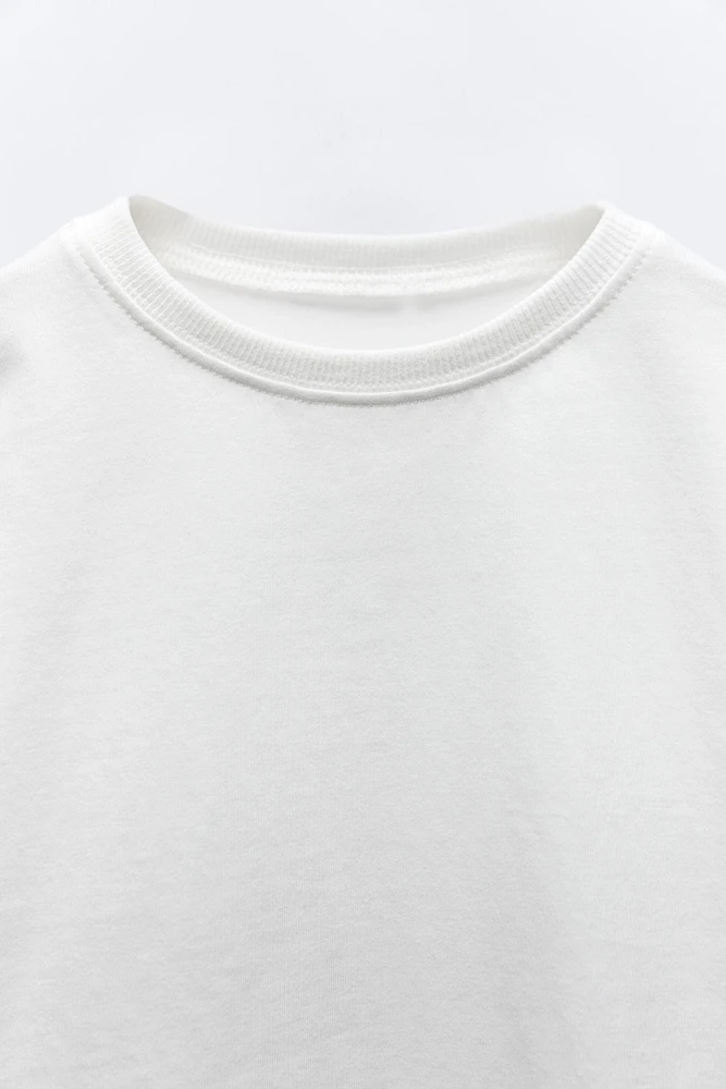 T-shirt with round neck and long sleeves. Label appliqué at back hem.