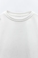 T-shirt with round neck and long sleeves. Label appliqué at back hem.
