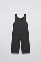 Sleeveless knit overalls with round neckline. Front floral embroidered detail.