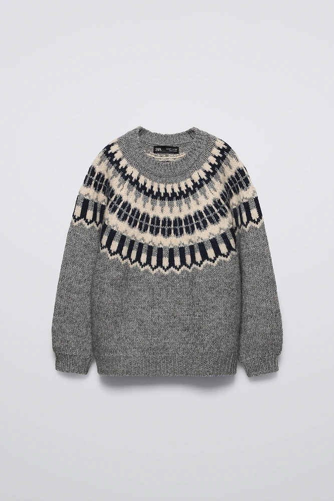 Long sleeve round neck sweater. Print detail at yoke.