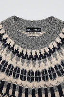 Long sleeve round neck sweater. Print detail at yoke.