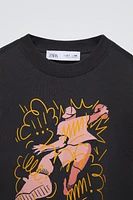 Round neck shirt with long sleeves. Front graffiti print. Label appliqué at sleeve.