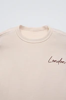 Round neck shirt with long sleeves. Contrasting embroidery detail on chest.