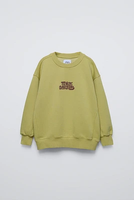 Round neck sweatshirt with long sleeves. Rib trim. Text print at chest and back embroidery detail. Warm soft interior.