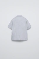 Collared short sleeve shirt. Front button closure at yoke. Patch pocket chest.