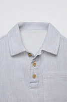 Collared short sleeve shirt. Front button closure at yoke. Patch pocket chest.